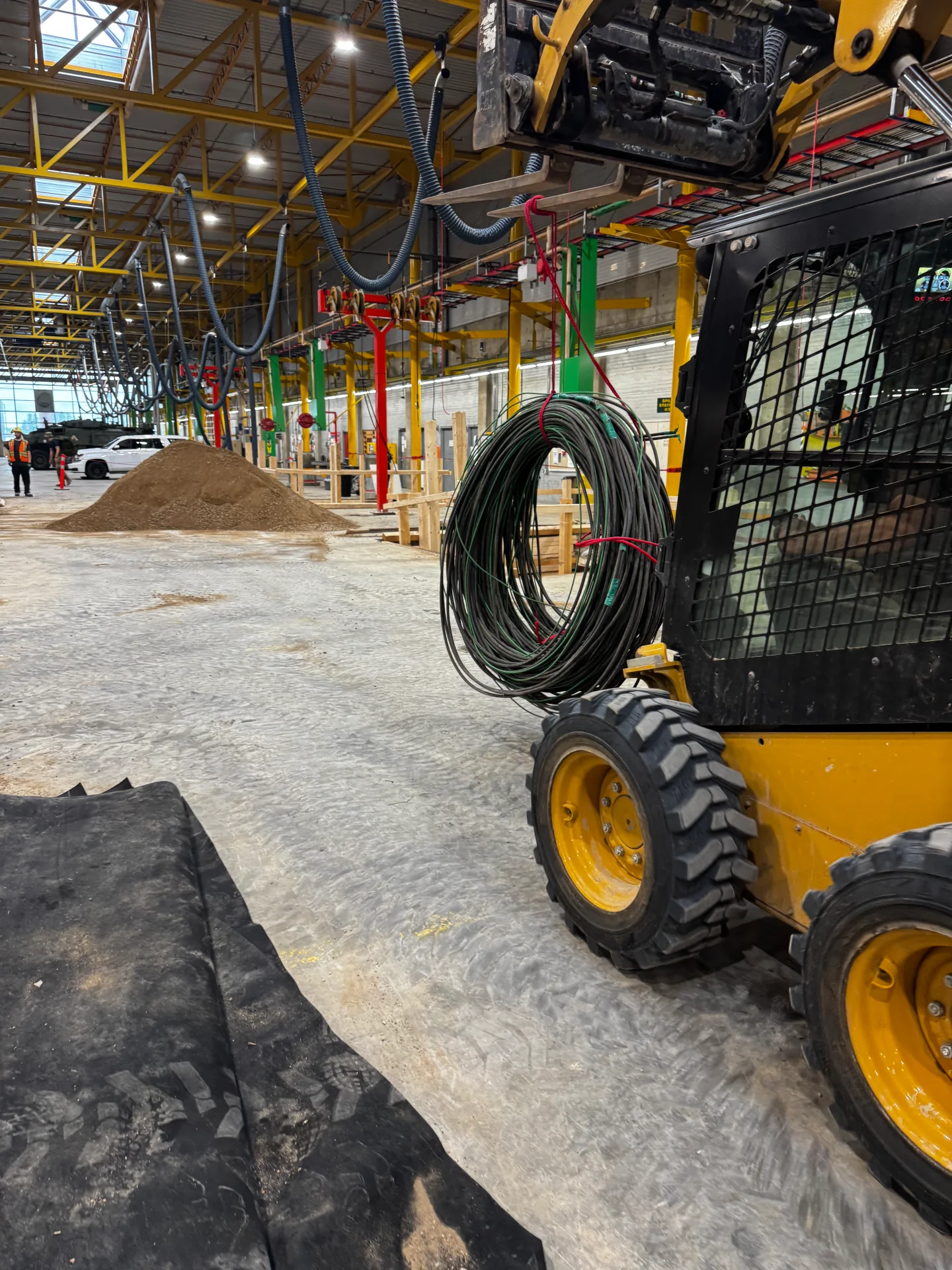 Bobcat Skidsteer Loader Carrying Rolled Up Feeder Wire RWU90 LiORA Electric Manitoba Electrical Contractor